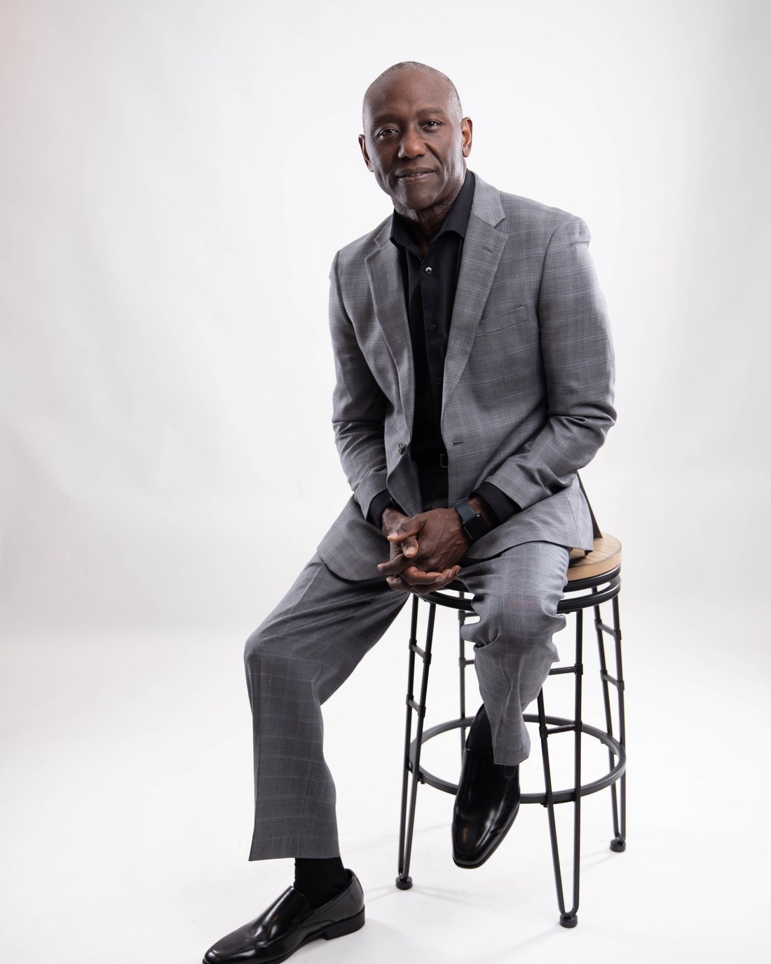 Dr. Mark A. Ballard, Sr., founder and broadcaster, in a tailored gray suit